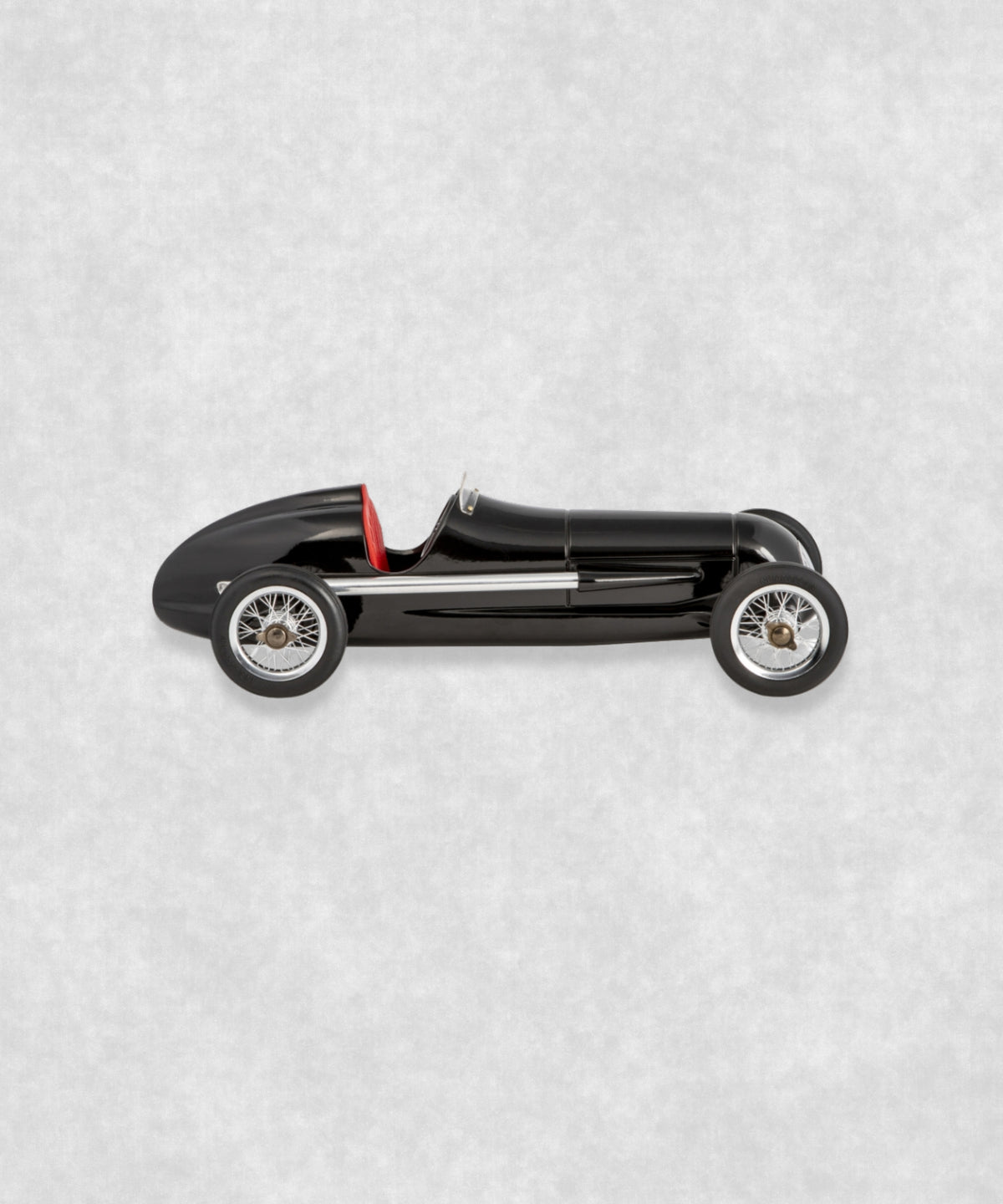 Vintage racing silberfeil car model inspired by classic Grand Prix racers and Silver Arrow legends, featuring a sleek black race car body with a striking red seat. A collectible car model for motorsport and classic car enthusiasts. Viewed from the left side.