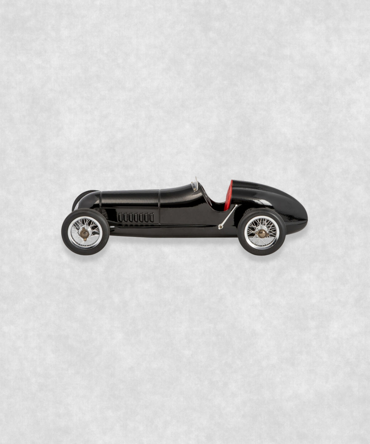 Vintage racing silberfeil car model inspired by classic Grand Prix racers and Silver Arrow legends, featuring a sleek black race car body with a striking red seat. A collectible car model for motorsport and classic car enthusiasts. Viewed from the right side.