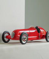 RVintage racing silberfeil car model inspired by classic Grand Prix racers and Silver Arrow legends, featuring a red race car body with a striking black seat. A collectible car model for motorsport and classic car enthusiasts. Viewed in situ