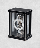 Side view of 14-day mechanical clock with black-painted natural wood frame – exposed movement, pendulum and hourly bell chime